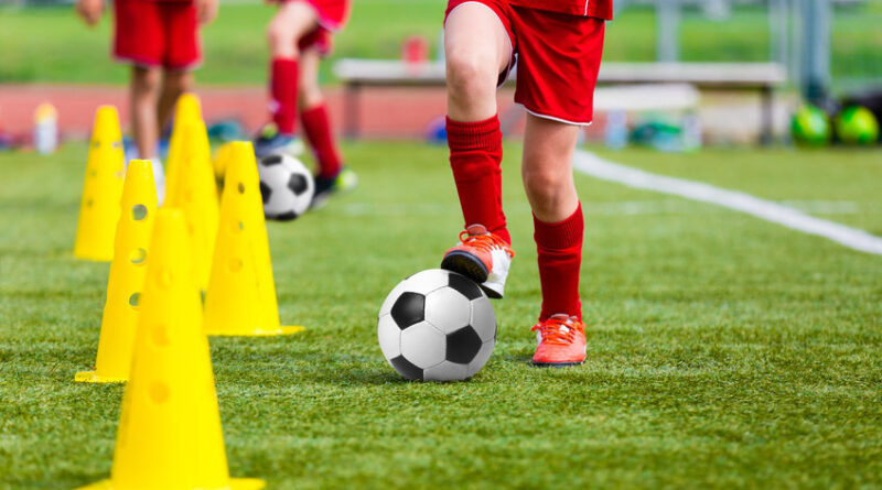 soccer football players during the team training before the match. exercises for football soccer youth team. young player exercises with ball and marker cones